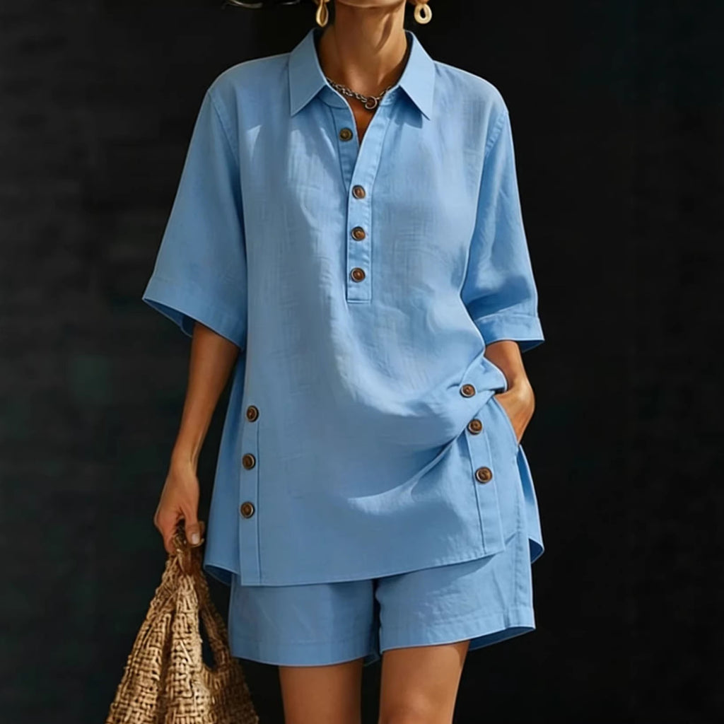 Person wearing a blue outfit with button details against a dark background