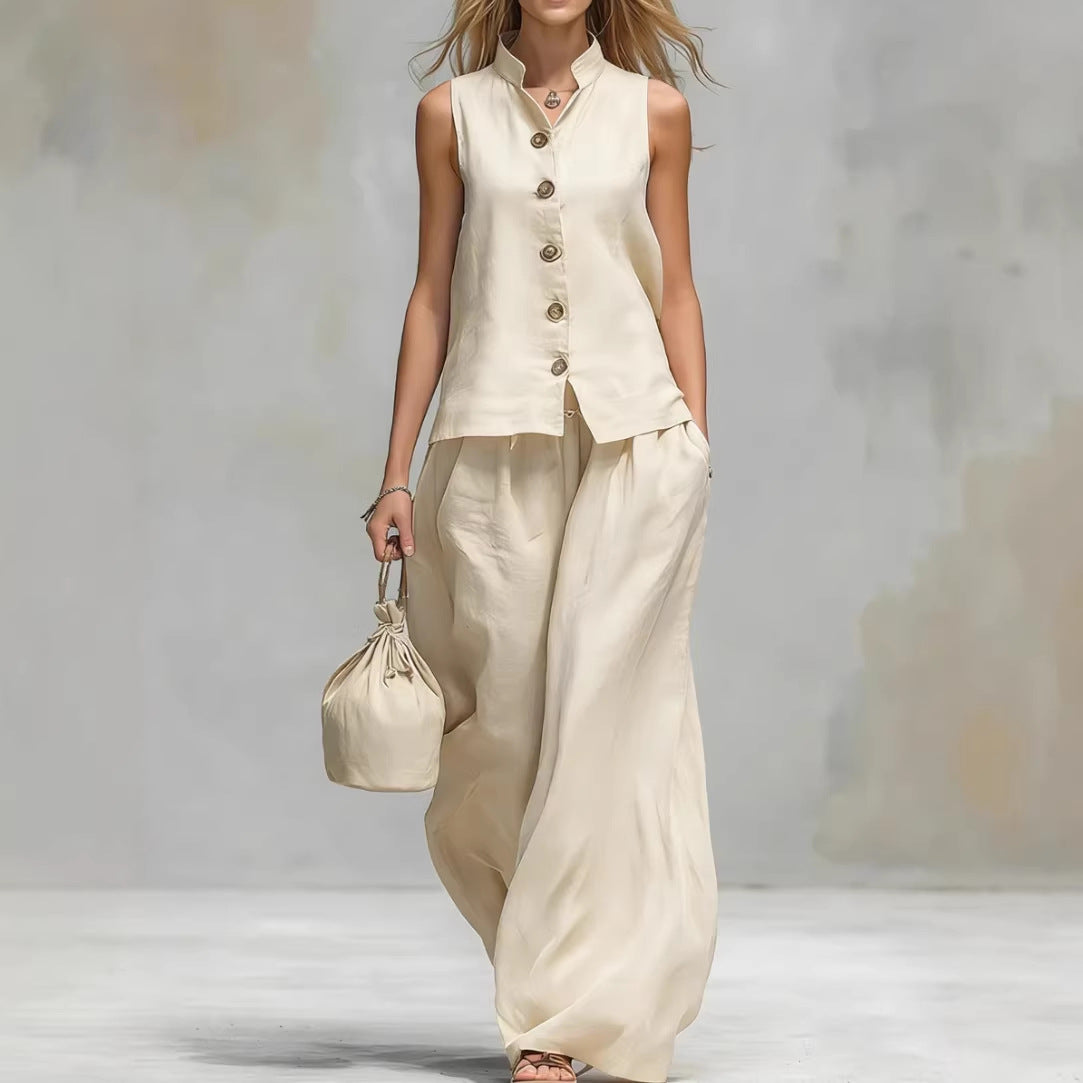 Woman wearing a beige sleeveless top and wide-leg pants holding a matching bag against a neutral background