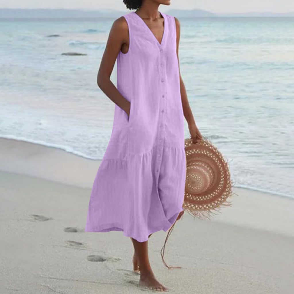 Woman in a purple dress holding a straw hat on a beach