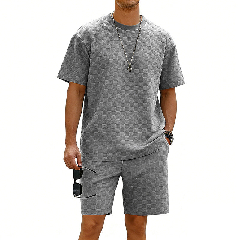 Man wearing a gray checkered outfit with sunglasses on a white background