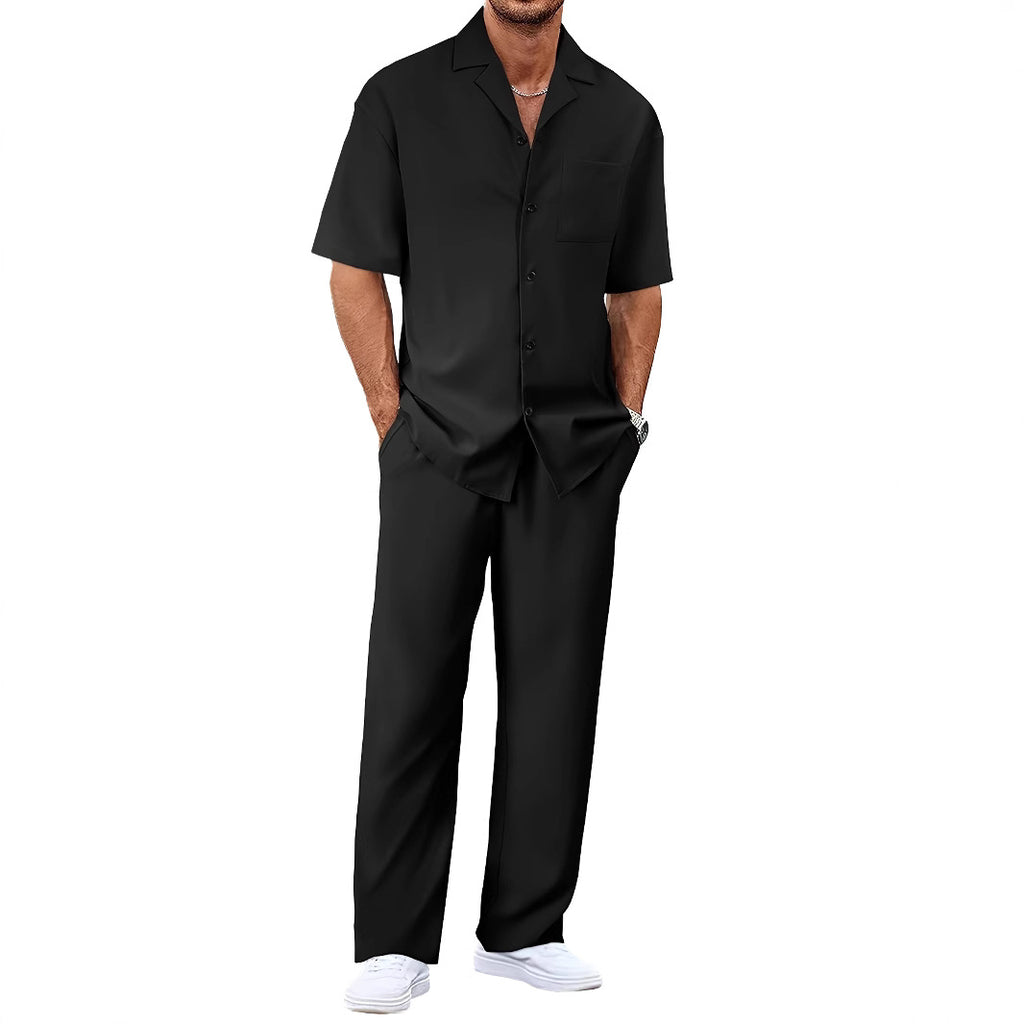 Person wearing a black shirt and pants with white shoes on a white background