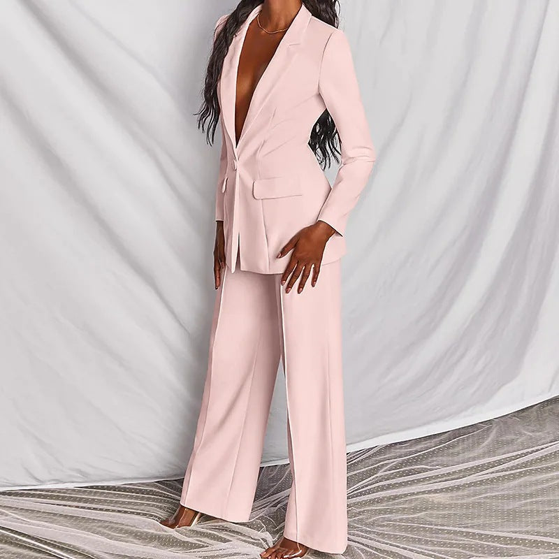 Person wearing a light pink suit against a plain background