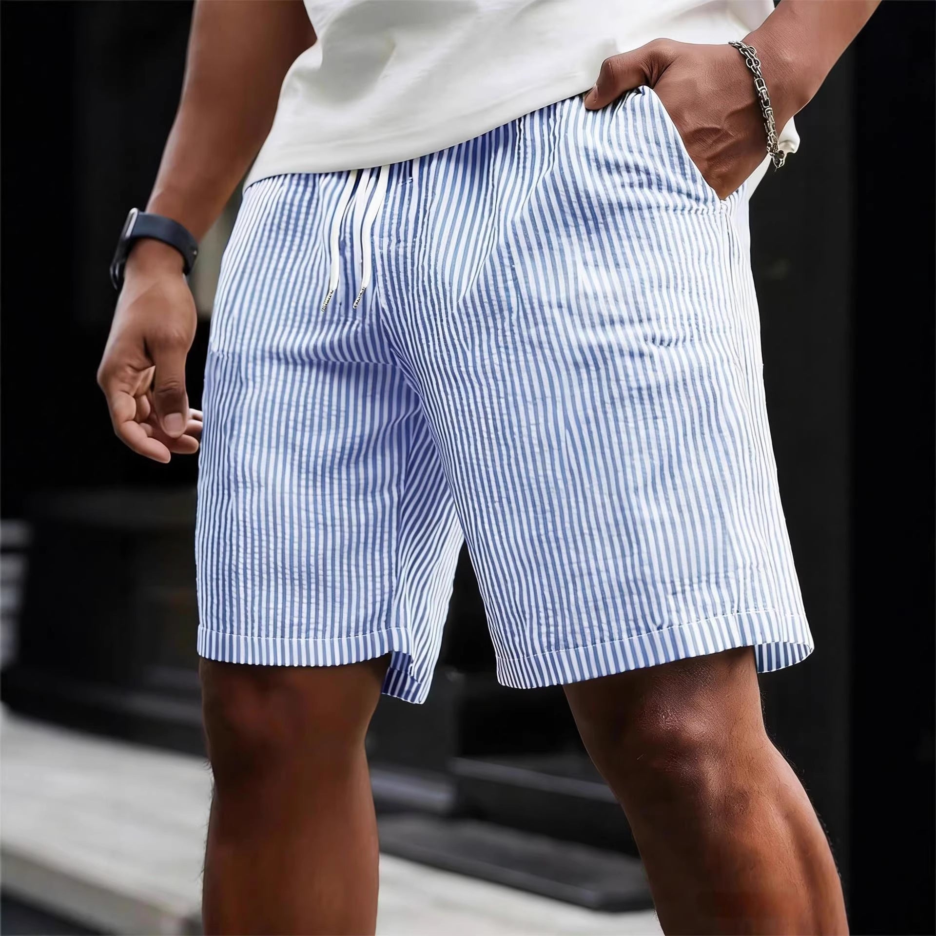 Person wearing blue and white striped shorts with a blurred background