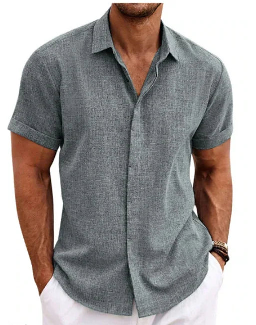 Man wearing a gray short-sleeve button-up shirt with white pants on a white background