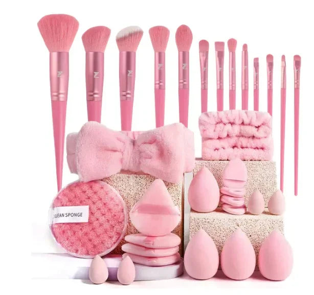 Pink makeup brush set with beauty sponges, headbands, and facial cleansing pads on display.