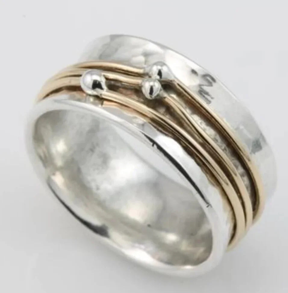 Silver ring with gold accents on a light gray background