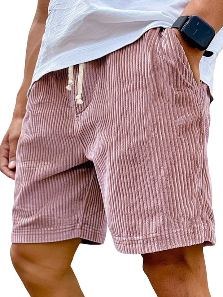 Person wearing pink striped shorts with a white shirt underneath on a plain background