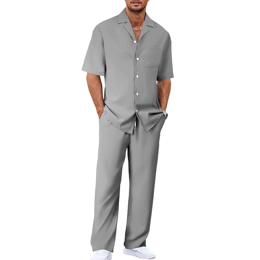 Man wearing a gray short-sleeve shirt and pants set on a white background