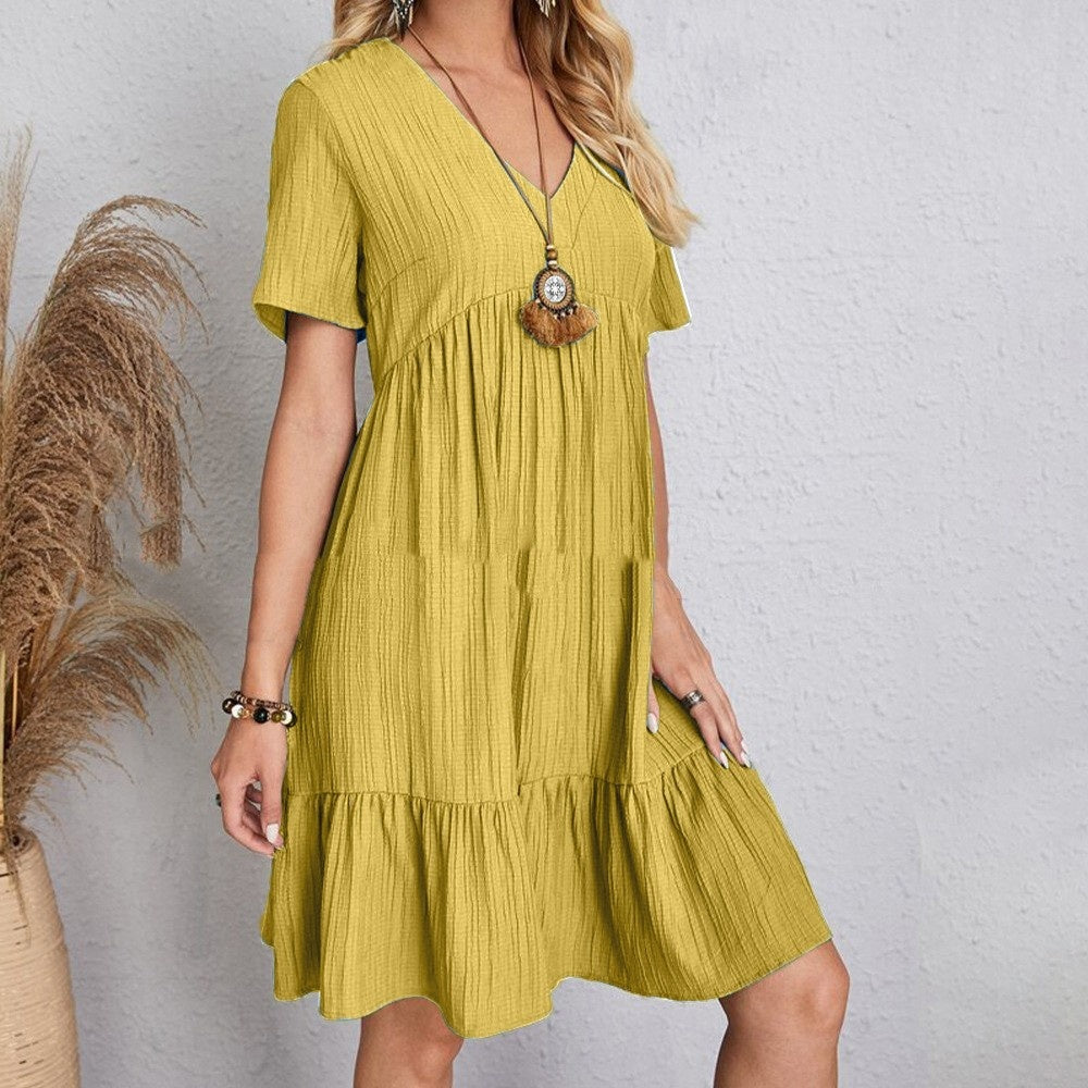 Woman wearing a yellow dress with a textured pattern against a plain background