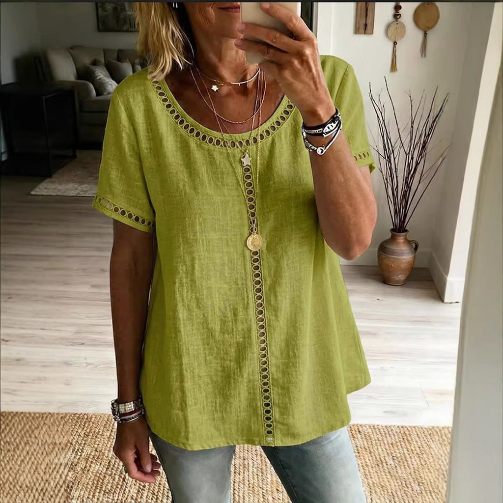 Person wearing a green top with decorative buttons in a living room setting.