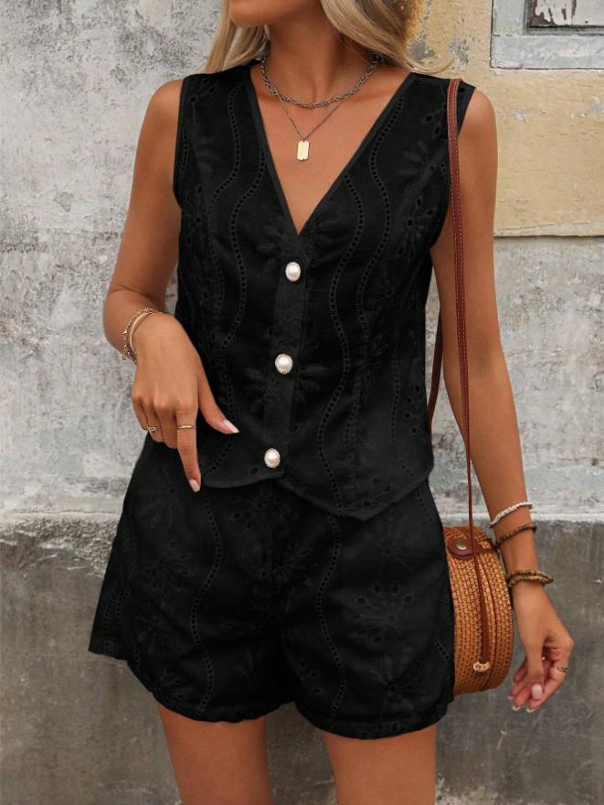 Woman wearing a black sleeveless top and shorts with white buttons, holding a brown handbag against a textured wall.