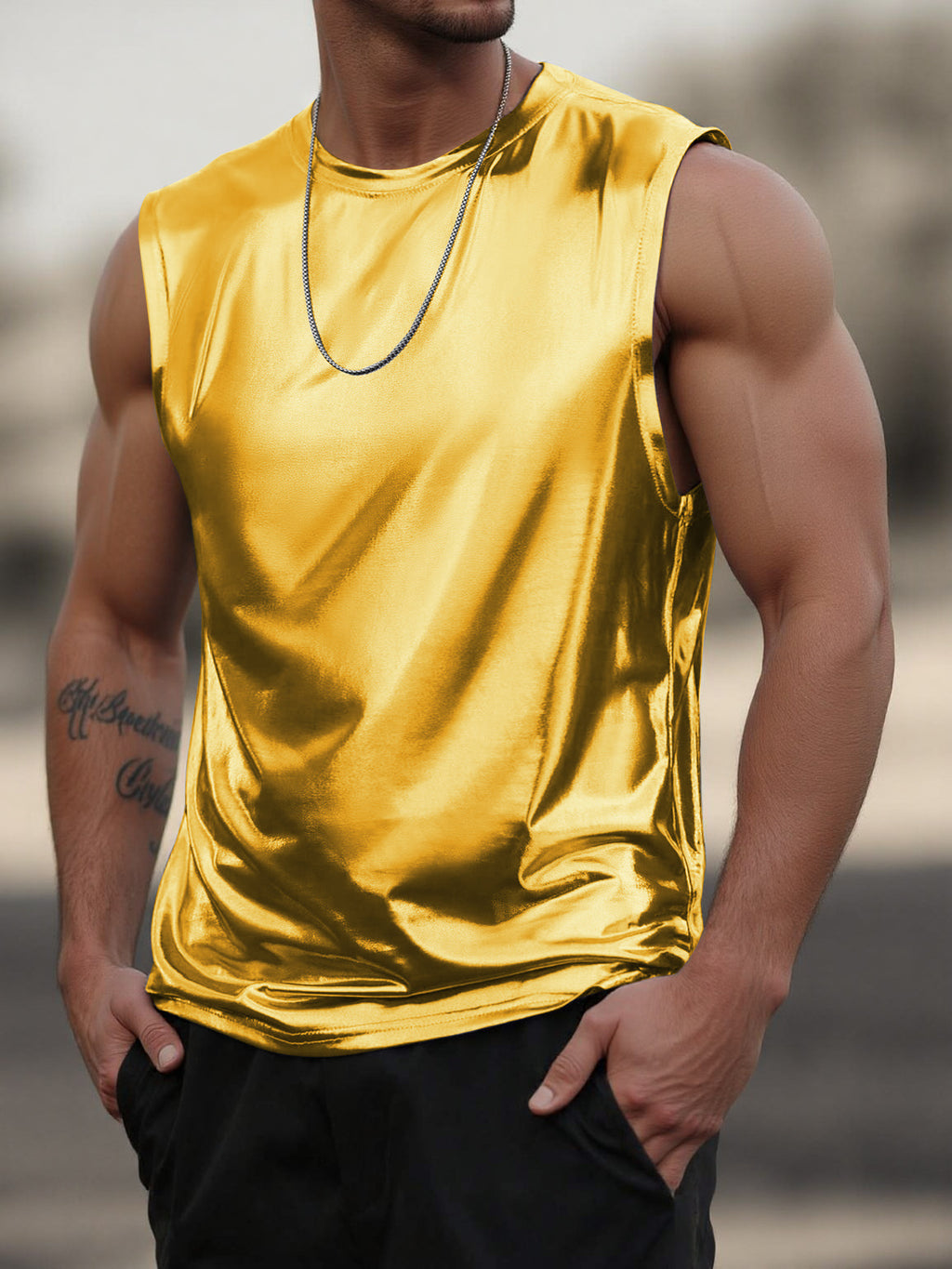 Person wearing a shiny gold tank top with a blurred background