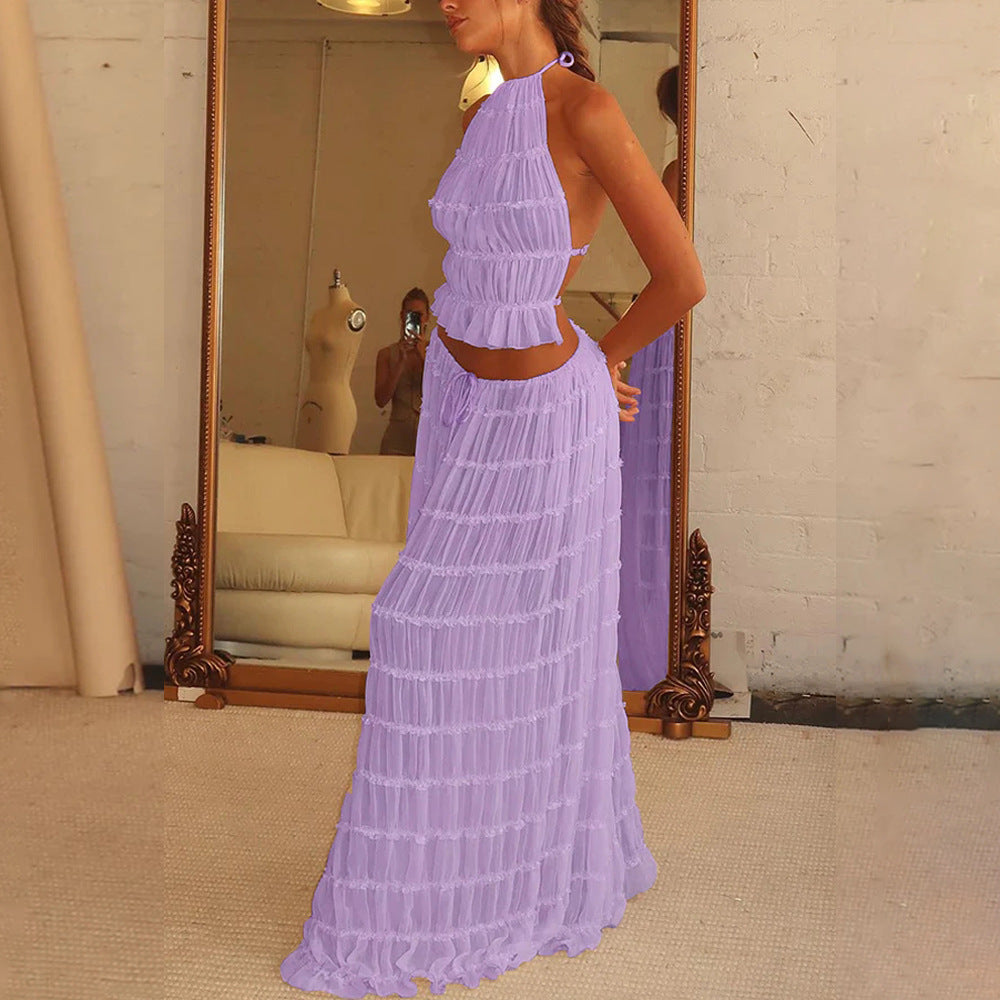 Woman wearing a purple dress standing in front of a mirror.