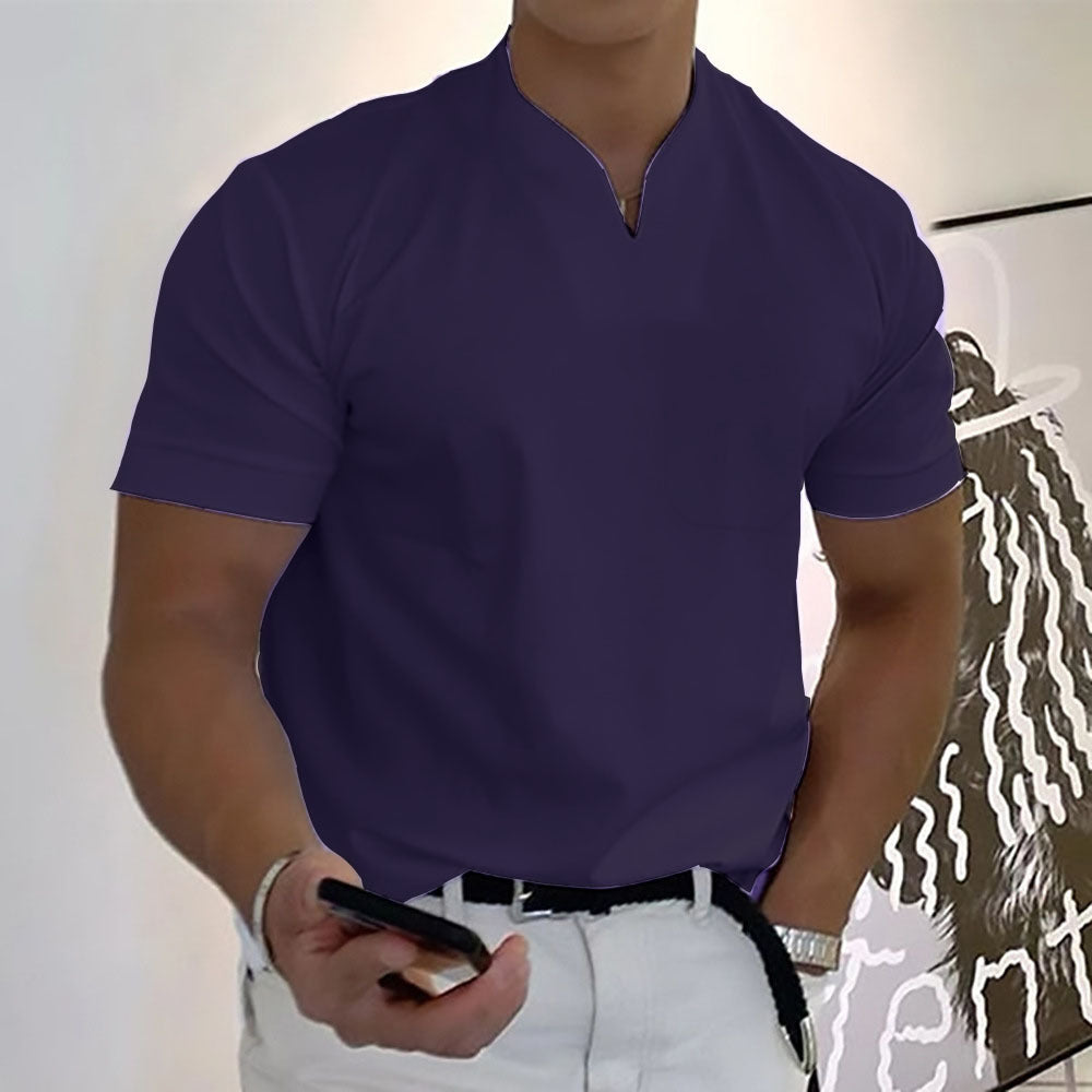 Person wearing a purple shirt holding a phone with a white wall and abstract painting in the background