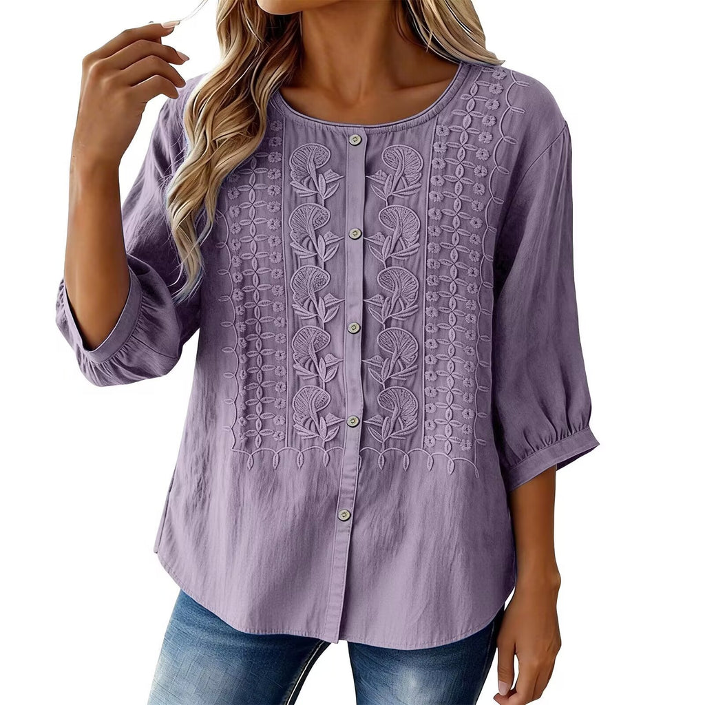 Purple embroidered blouse worn by a model on a white background
