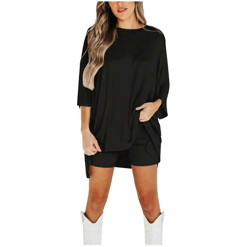Woman modeling ZA-Zola black oversized top and shorts with white boots, trendy outfit