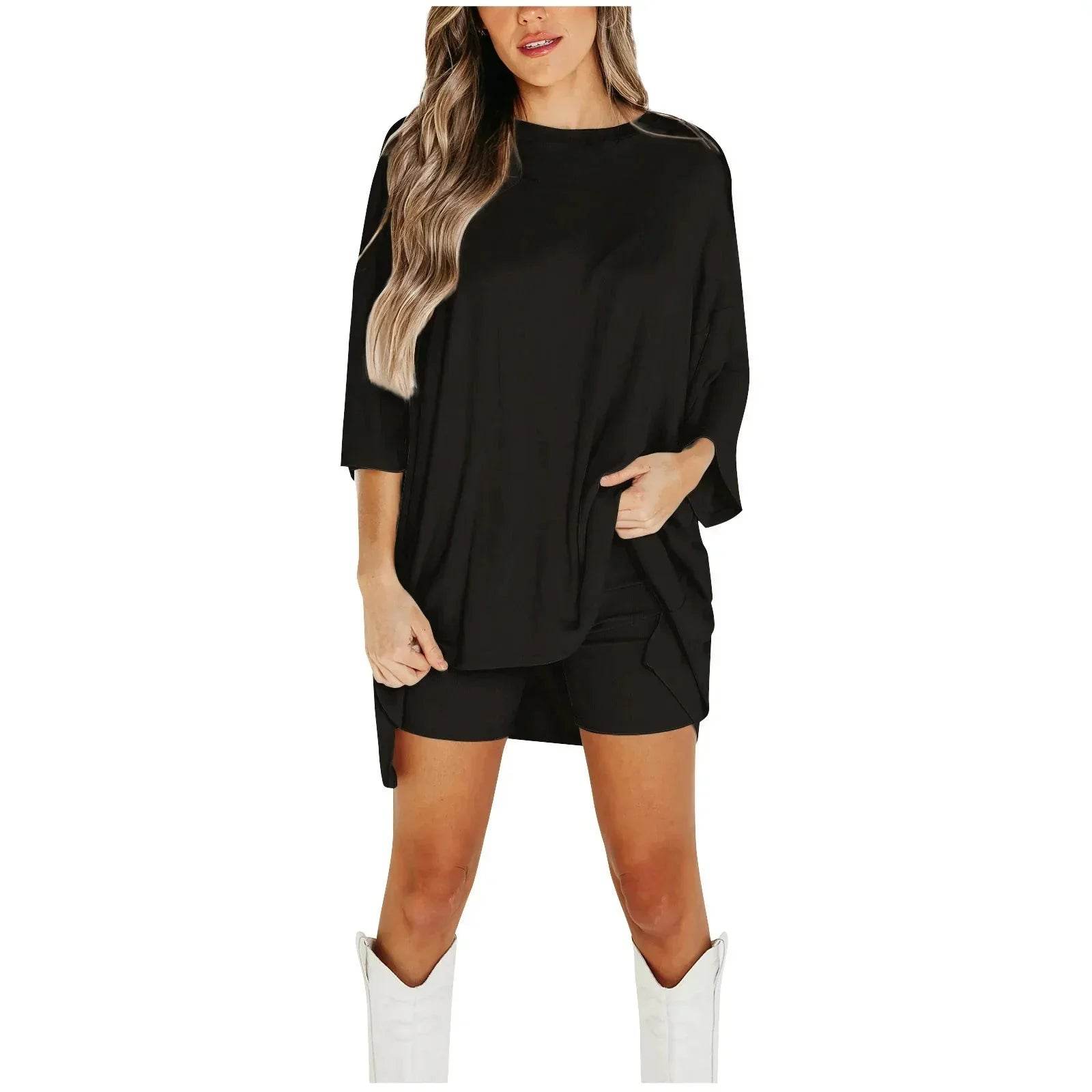 Woman modeling ZA-Zola black oversized top and shorts with white boots, trendy outfit