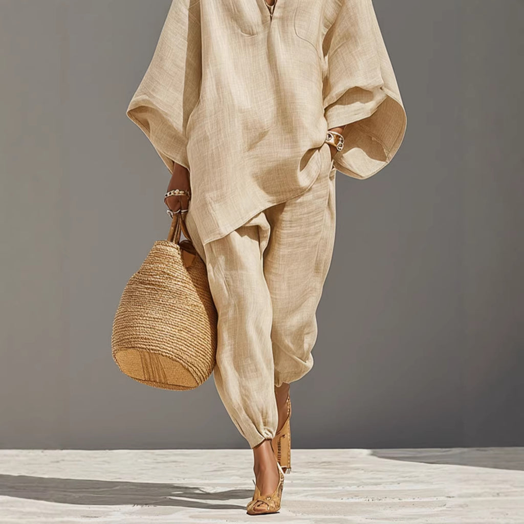 Person wearing a beige outfit holding a woven bag on a gray background