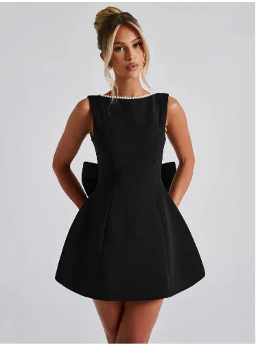 Woman wearing a black dress against a plain background