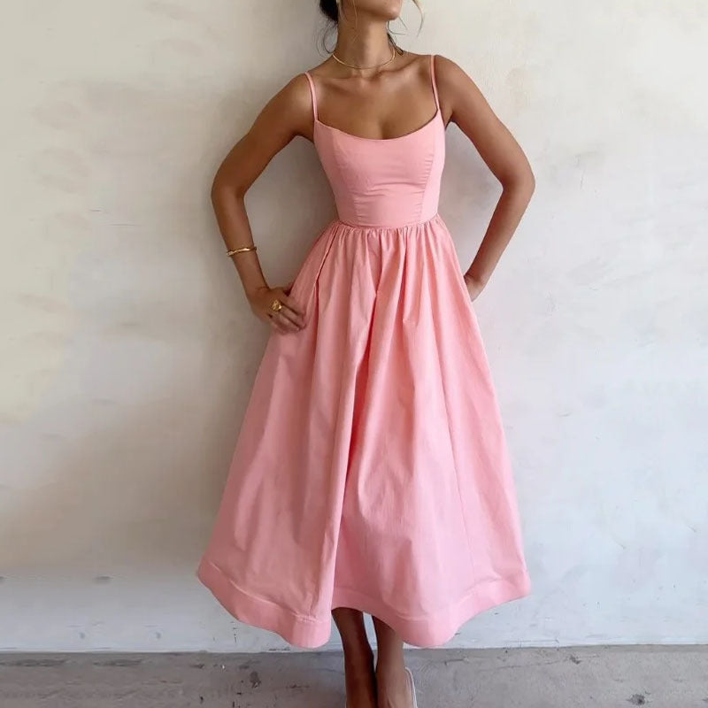 Woman wearing a pink dress against a plain background