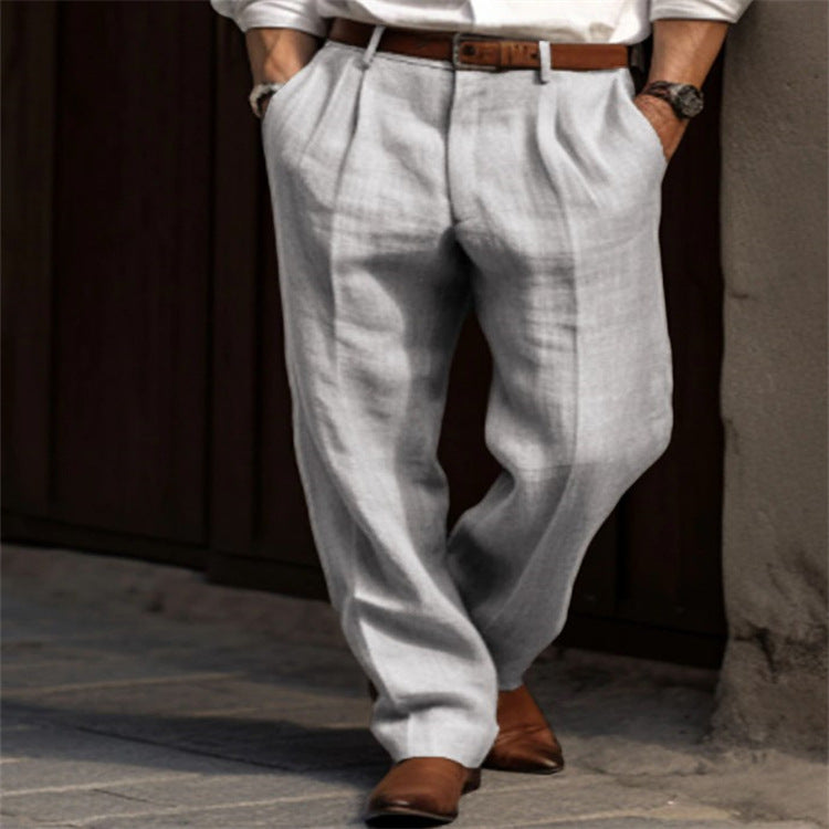 Person wearing light gray pants and brown shoes against a dark background