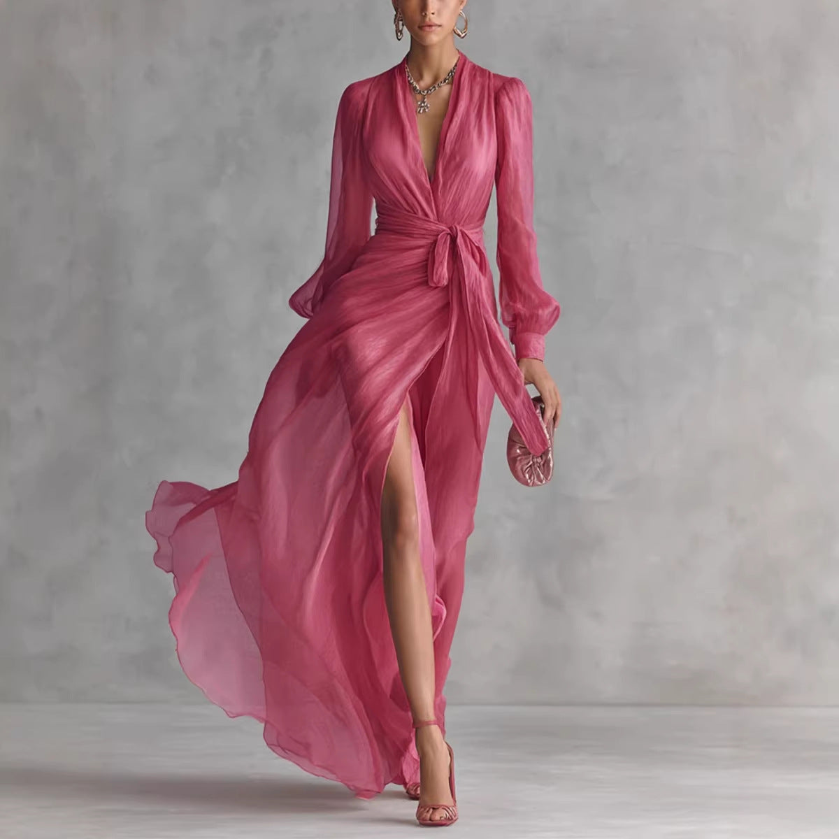 Woman wearing a pink dress with a high slit on a plain background