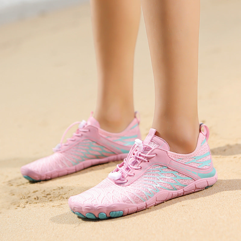 Pink and blue athletic shoes on a sandy background