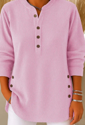 Pink ribbed sweater with buttons worn by a person, on a plain background
