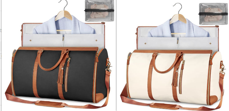 Black and white duffel bag with brown leather accents on a white background
