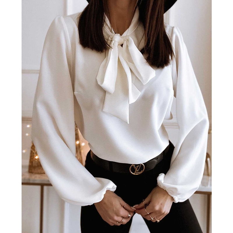 White blouse with a bow tie worn by a person, blurred background