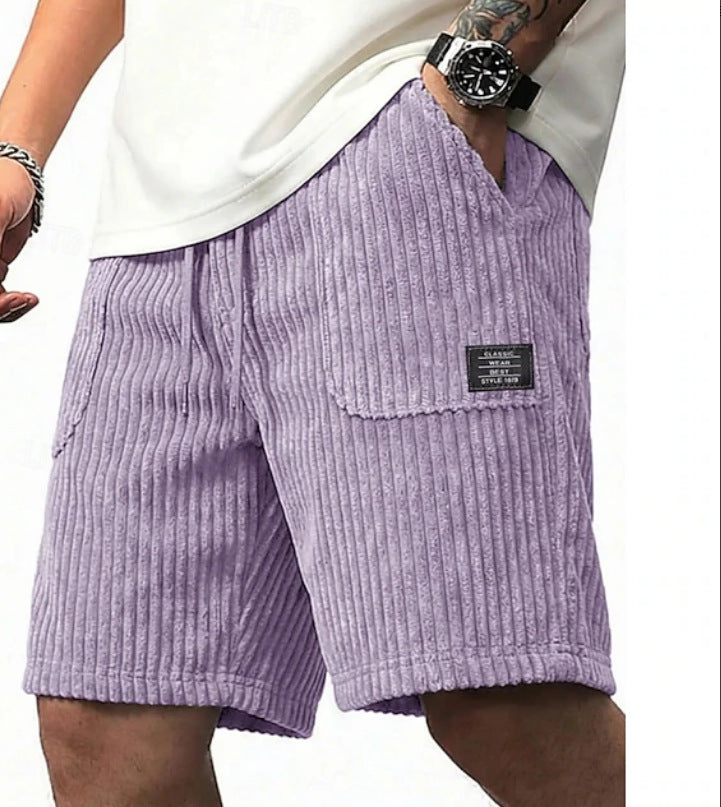 Purple corduroy shorts worn by a person on a white background