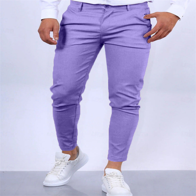 Person wearing purple pants and white sneakers on a plain background