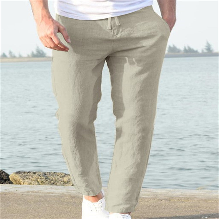 Person wearing beige pants standing by a body of water.