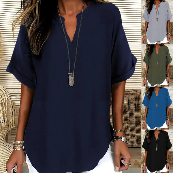 Woman wearing a navy blue blouse with a necklace, surrounded by color swatches of other blouses.