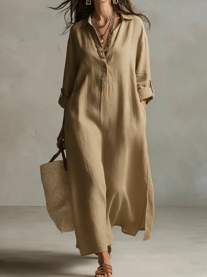 Woman wearing a long beige dress holding a woven bag against a neutral background