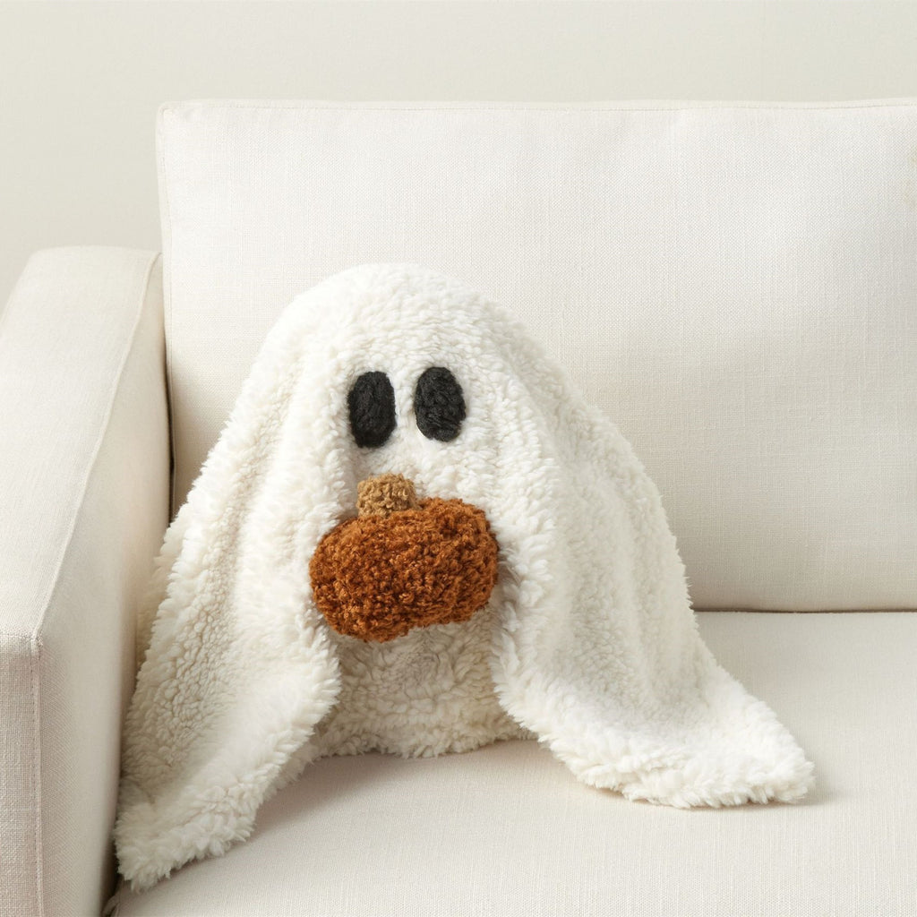 White plush ghost with black eyes and brown nose on a white couch