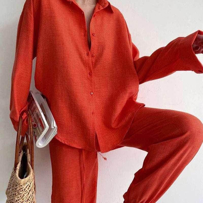 Woman in loose red button-up shirt and pants holding magazine and straw bag, ZA-Zola fashion