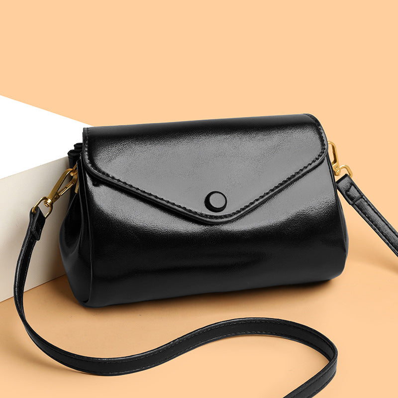 Black handbag with a strap on a beige background