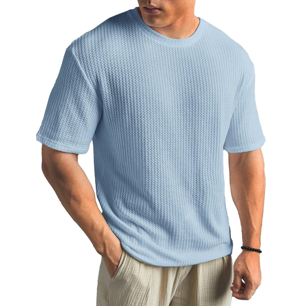 Man wearing a textured light blue t-shirt on a white background