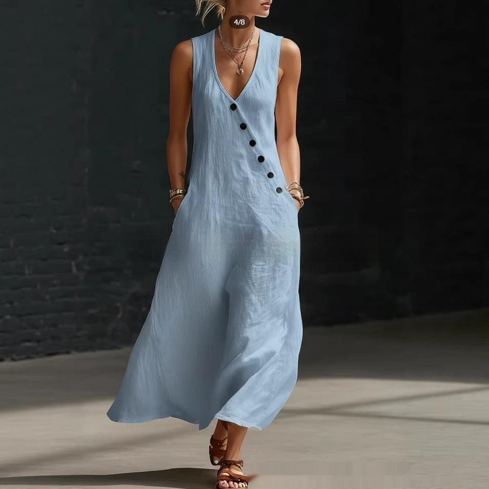 Woman wearing a light blue sleeveless dress with black buttons against a dark background