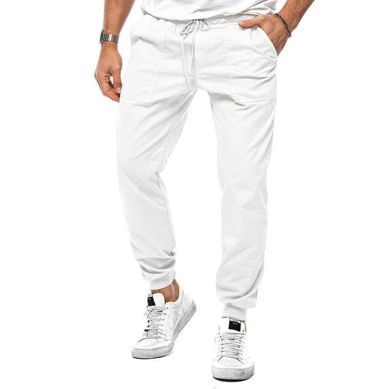 Person wearing white jogger pants and white sneakers on a white background