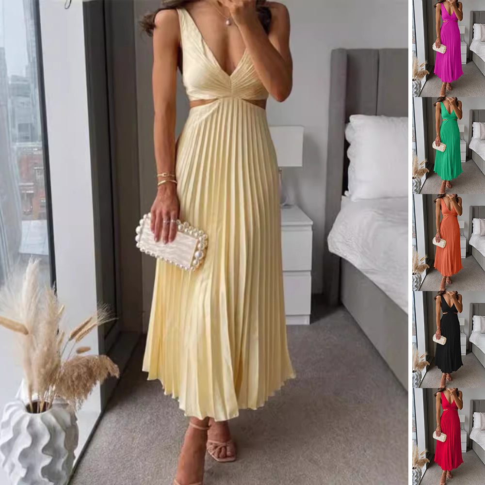 Woman in a yellow pleated dress holding a clutch in a bedroom setting.