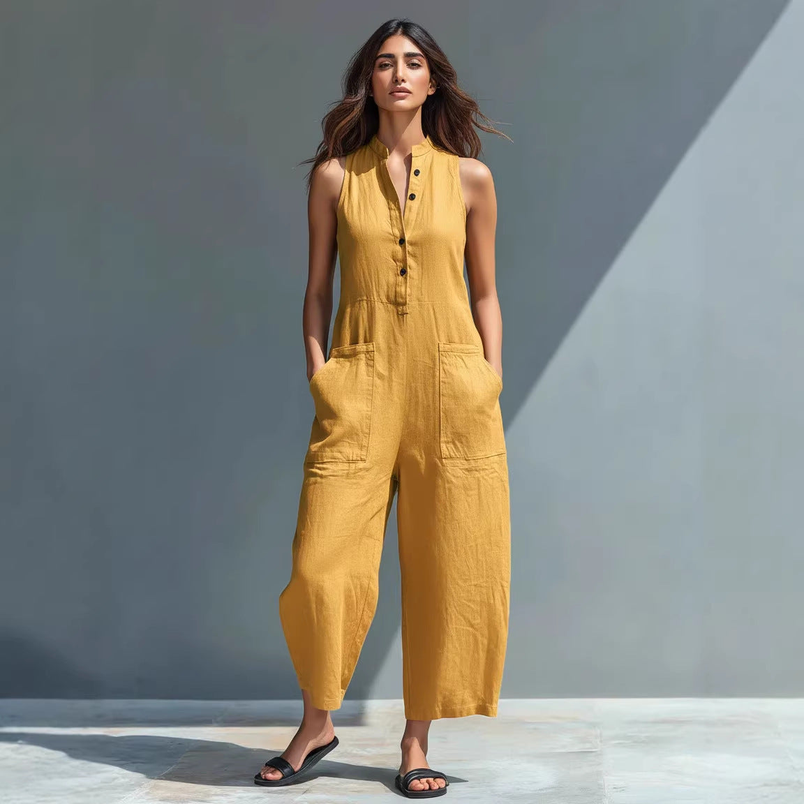 Woman wearing a yellow jumpsuit against a gray background