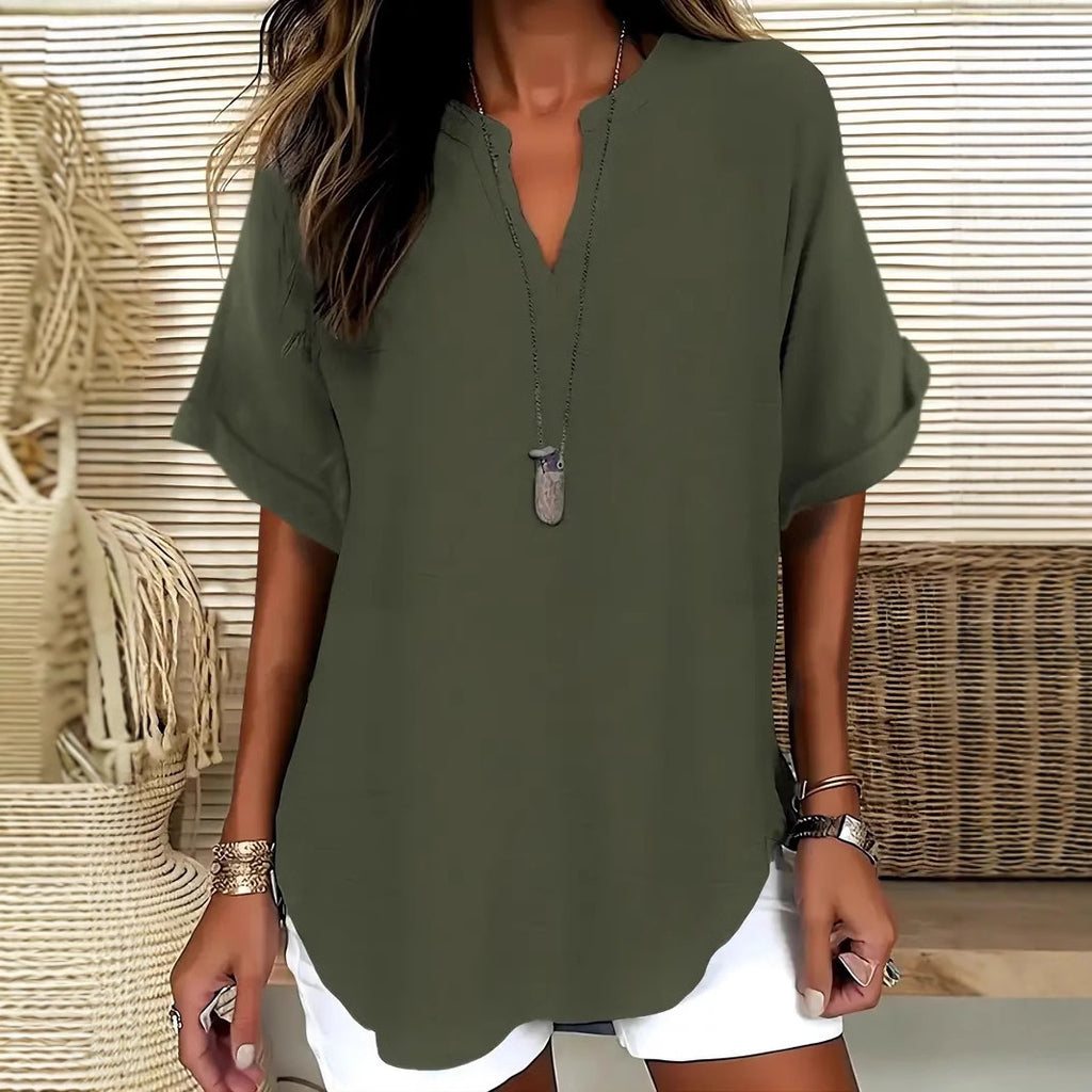 Person wearing a green oversized shirt with a neutral background
