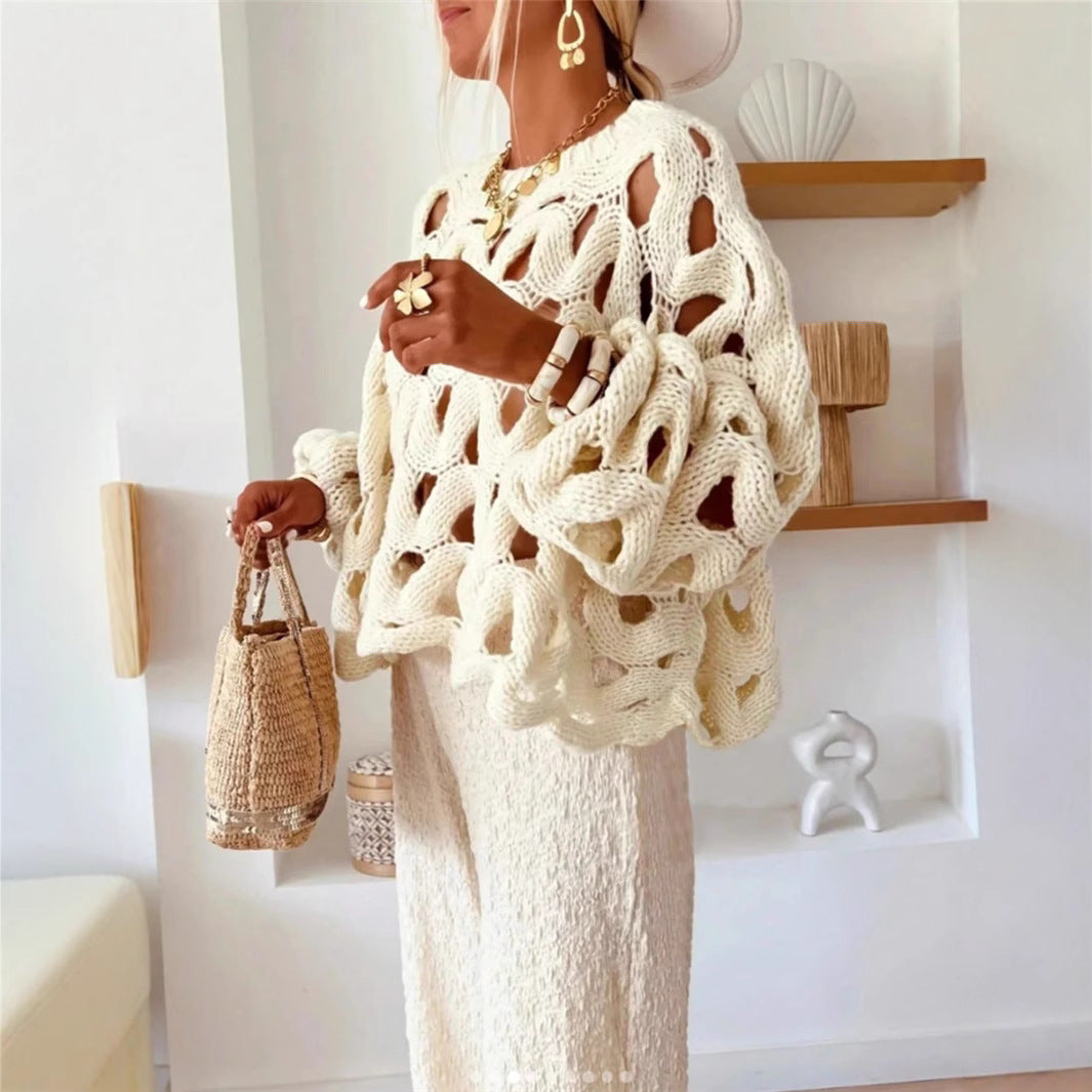 Woman wearing a white crochet cardigan and holding a straw bag indoors.