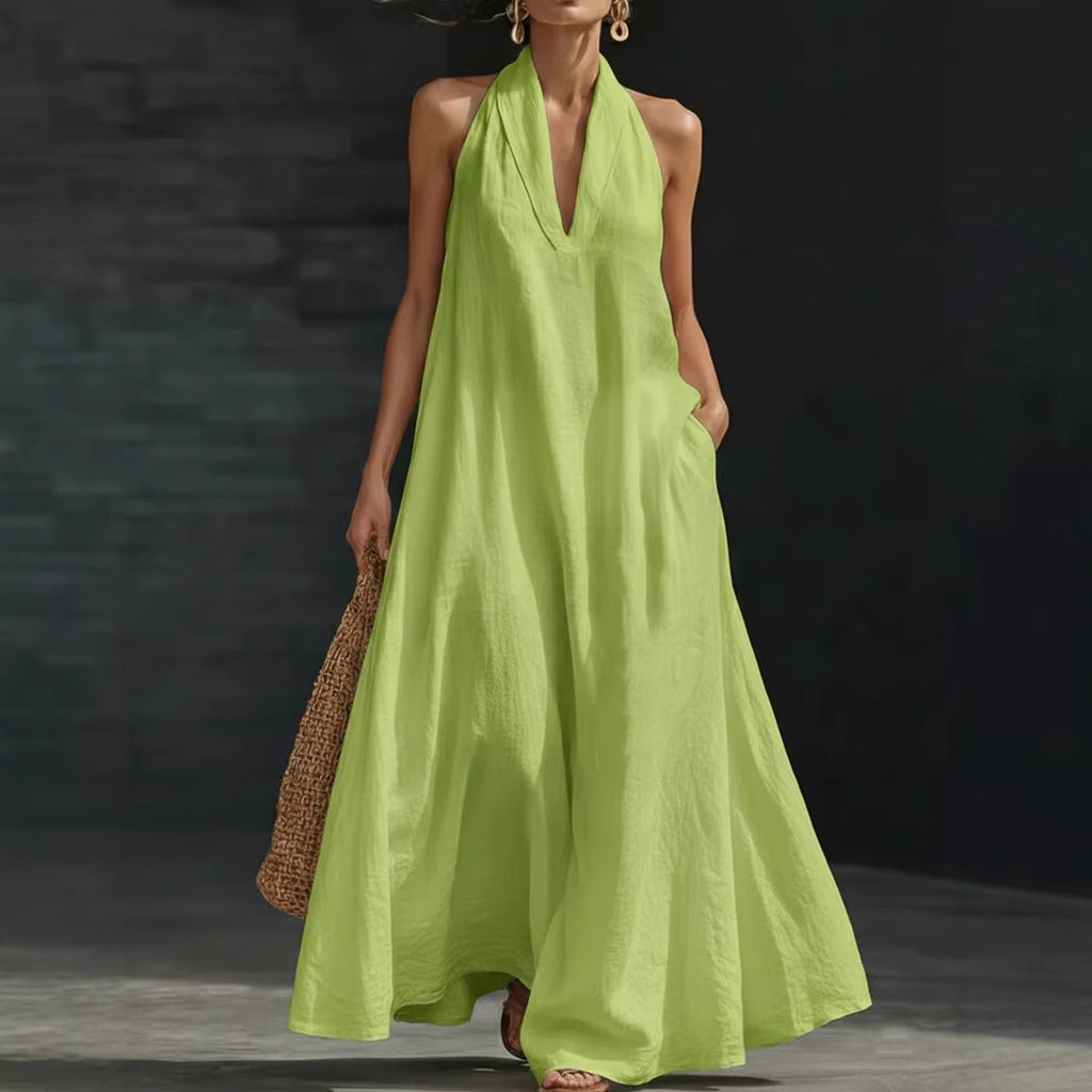 Woman wearing a bright green dress holding a woven bag against a dark background
