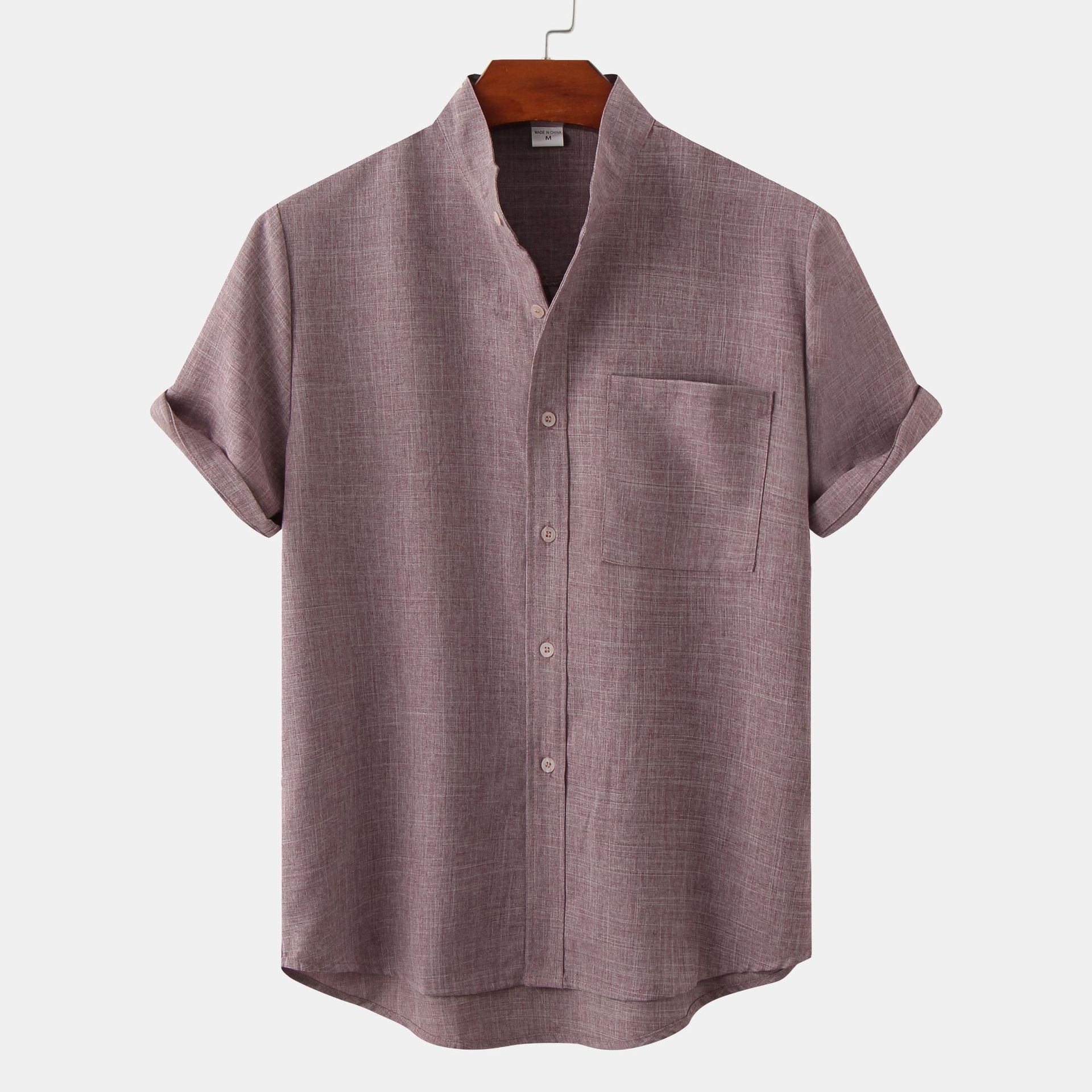 Purple short-sleeve shirt on a hanger against a white background