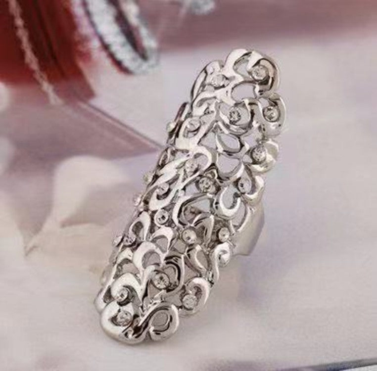Silver ring with intricate design on a light background