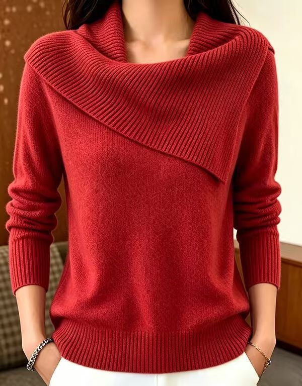 A woman wearing a red knit sweater with a wide draped cowl neckline, long sleeves, and ribbed cuffs and hem, paired with white pants.