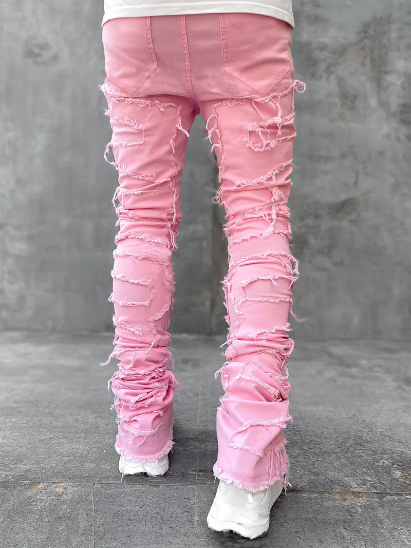 Pink ripped jeans worn by a person on a gray concrete floor.